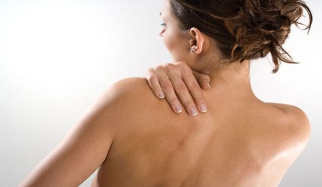 La femme s'inquiète de la douleur sous l'omoplate gauche dans le dos par derrière